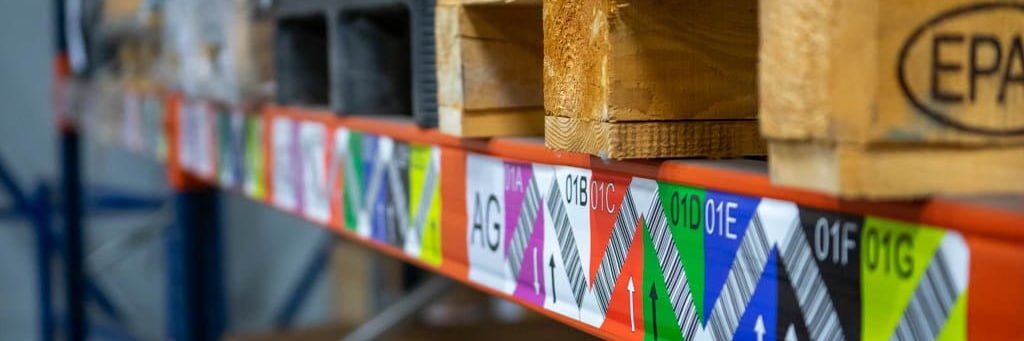 Regal mit farbigen Barcode-Etiketten je Fach und Paletten für Logistik und Produktionssteuerung