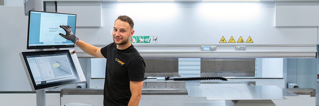 Mitarbeiter von Contour an den Touchscreens einer CNC-Abkantpresse, ein Blech liegt bereit