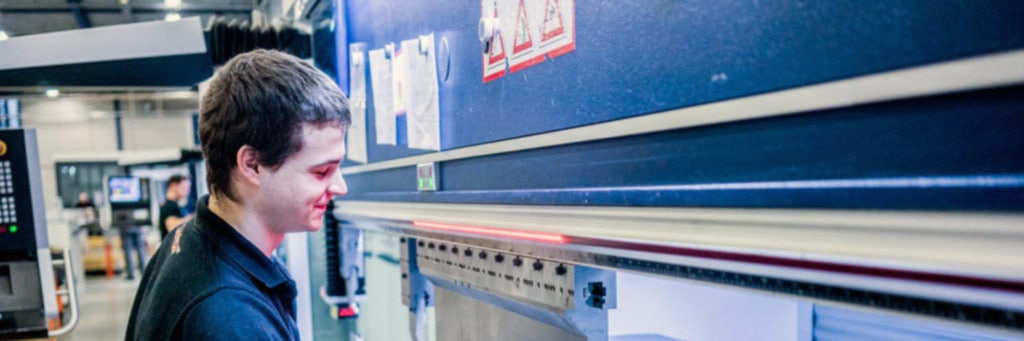 Contour employee places a sheet in a blue CNC press brake