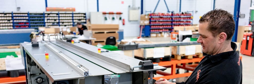 Contour assembler mounts a part on a metal frame on a pallet in the assembly hall