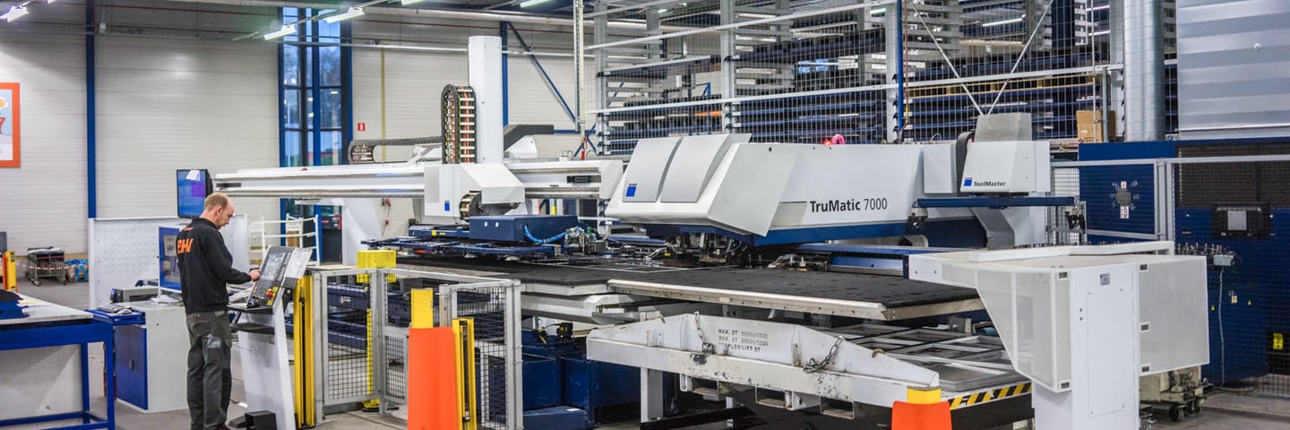 Contour employee operating the Trumpf TruMatic 7000 punch laser in the production hall