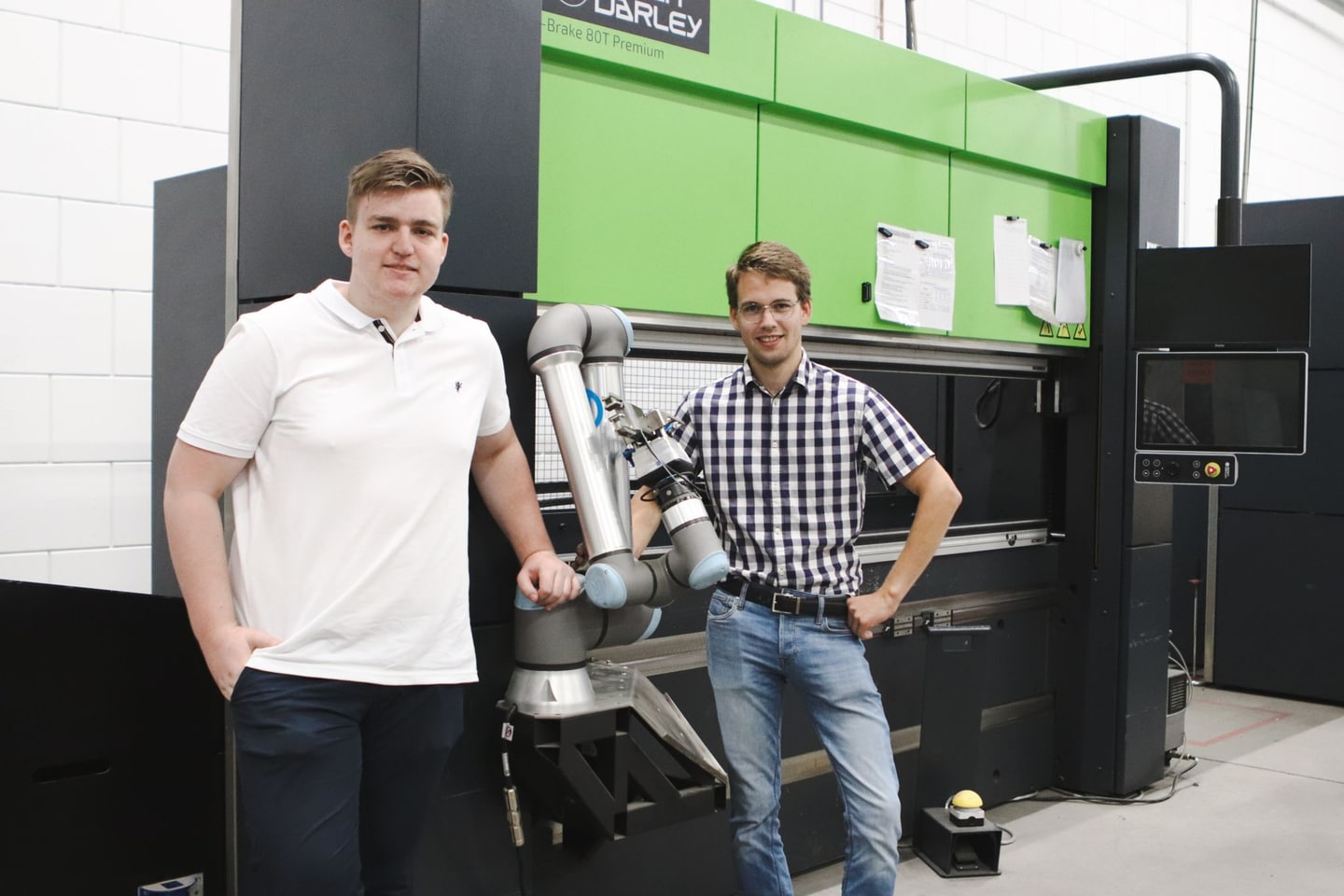 Twee nieuwe studenten staan naast een kantbank met een cobot