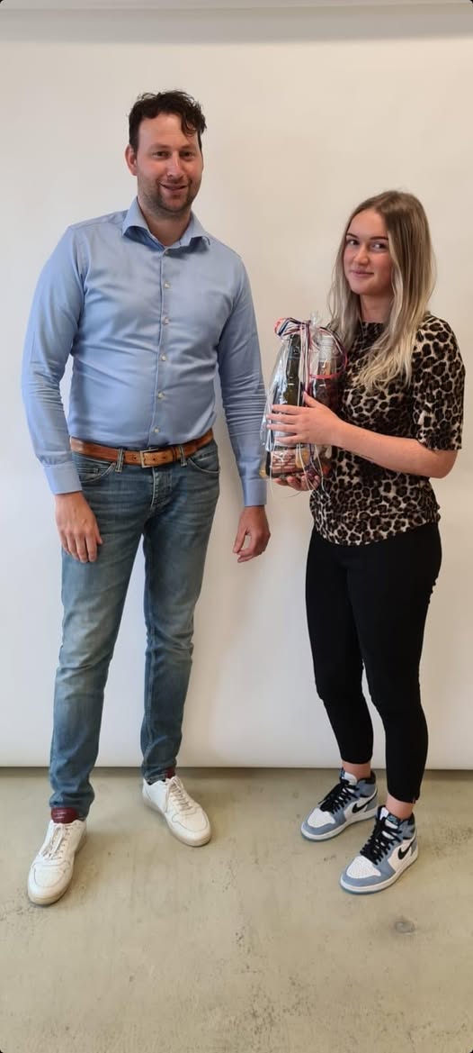 Een man en een vrouw met een cadeau voor een witte wand