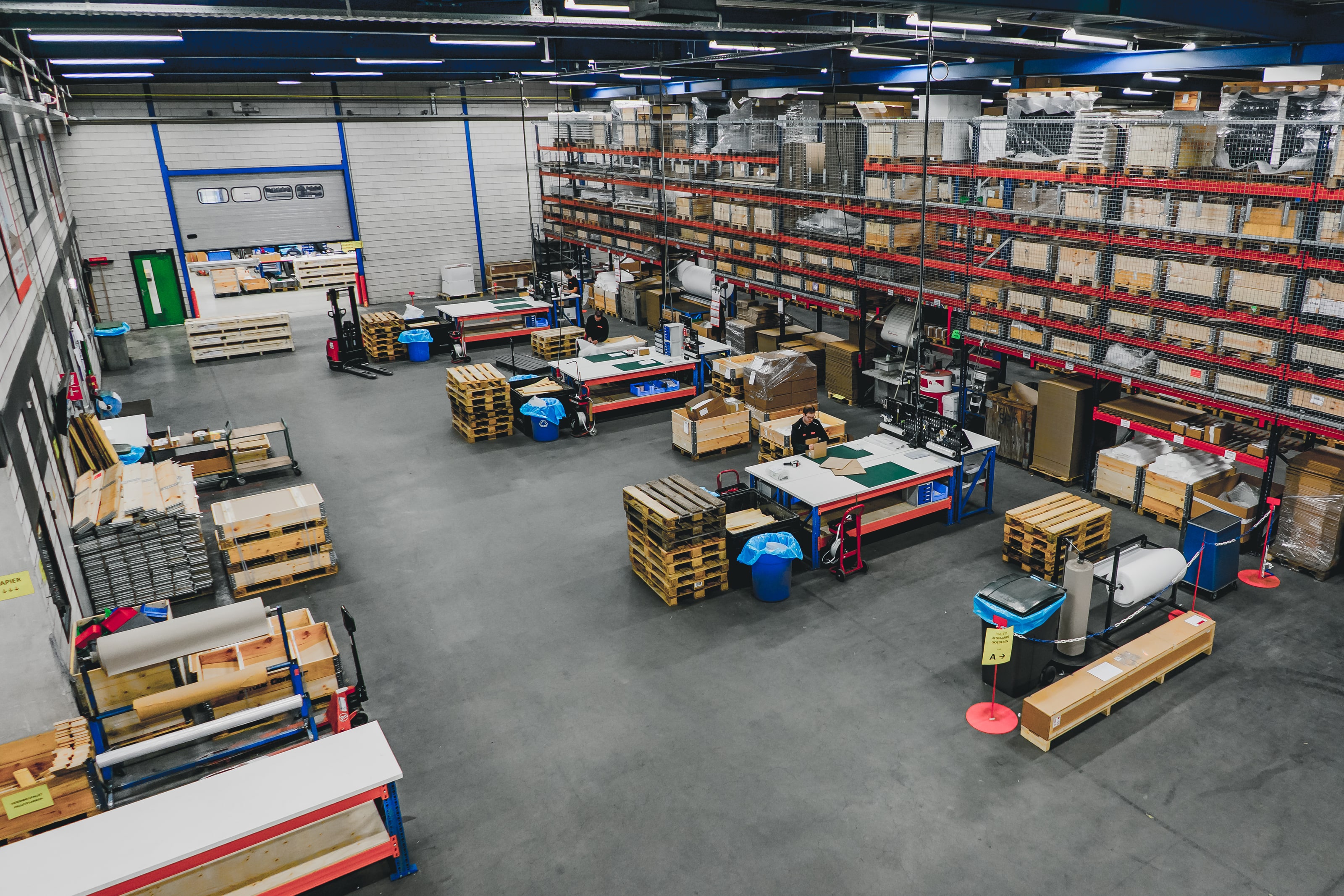 Overzicht van het magazijn van Contour met stellingen, pallets en inpaktafels