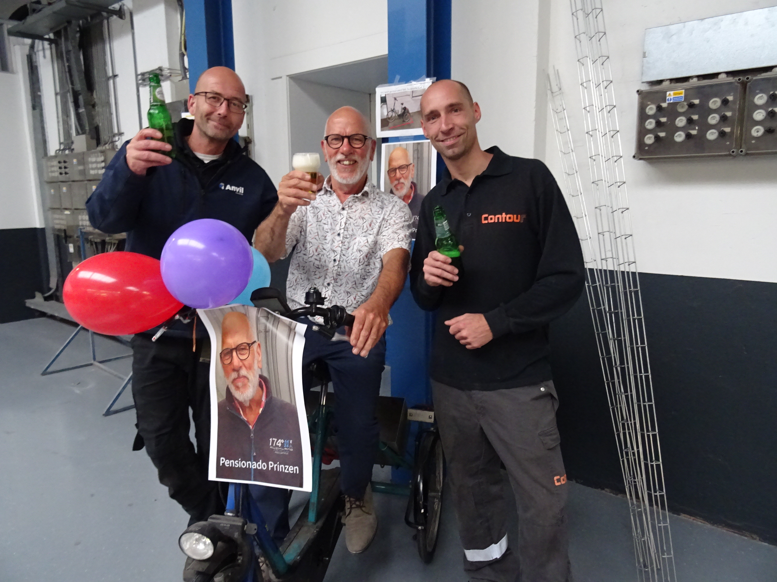 Drei Kollegen stoßen mit Bier an, mit Luftballons und einem Poster „Pensionado Prinzen“
